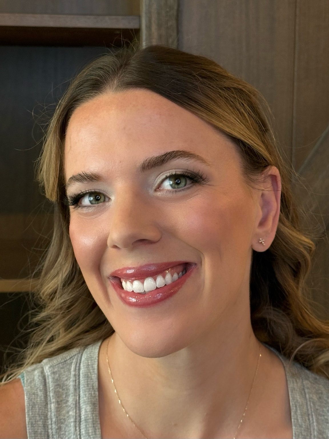 Soft glam makeup with champagne shimmer eyeshadow, green eyes, and a glossy rose lip